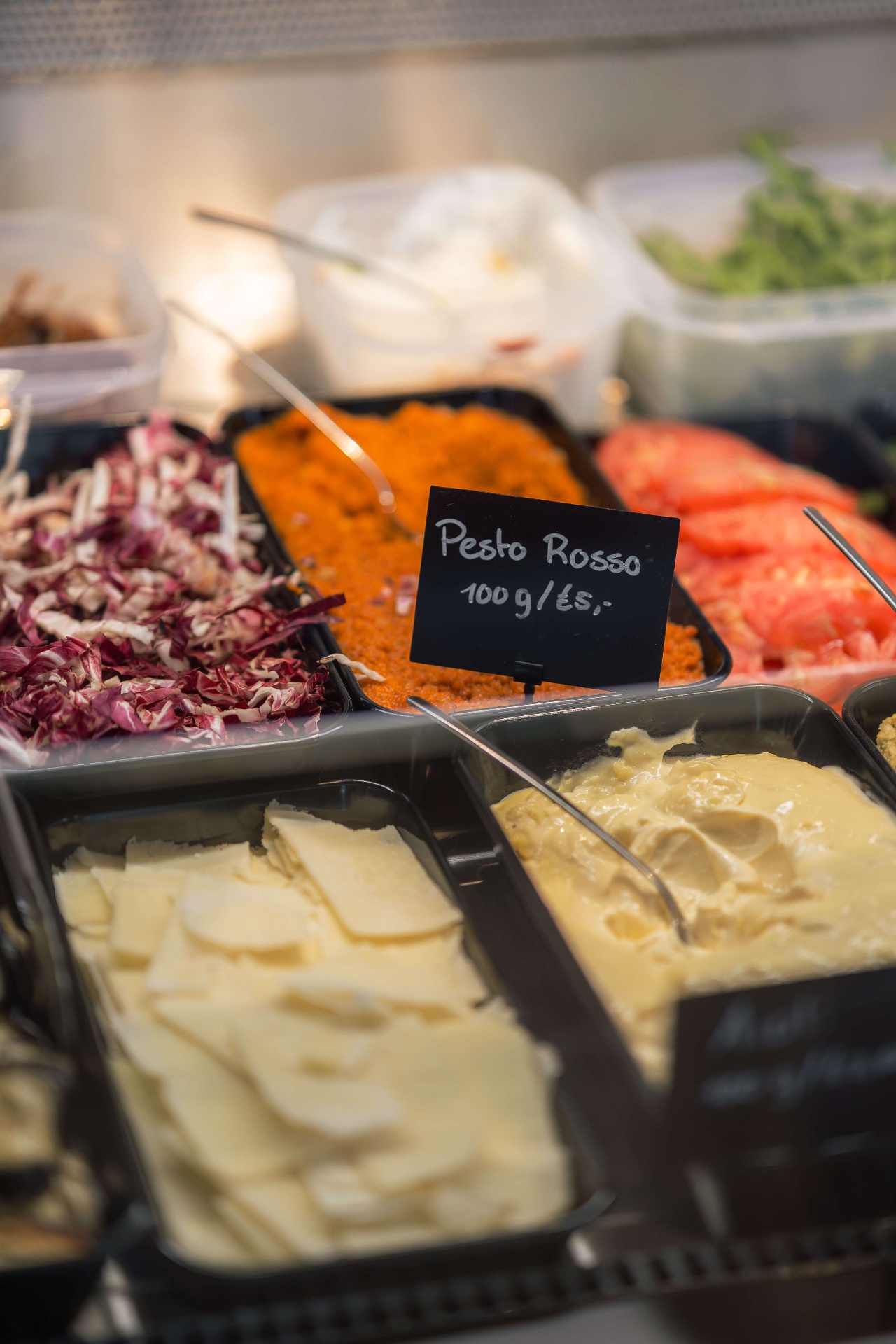 Verse pesto rosso, radicchio en Italiaanse kazen in de vitrine