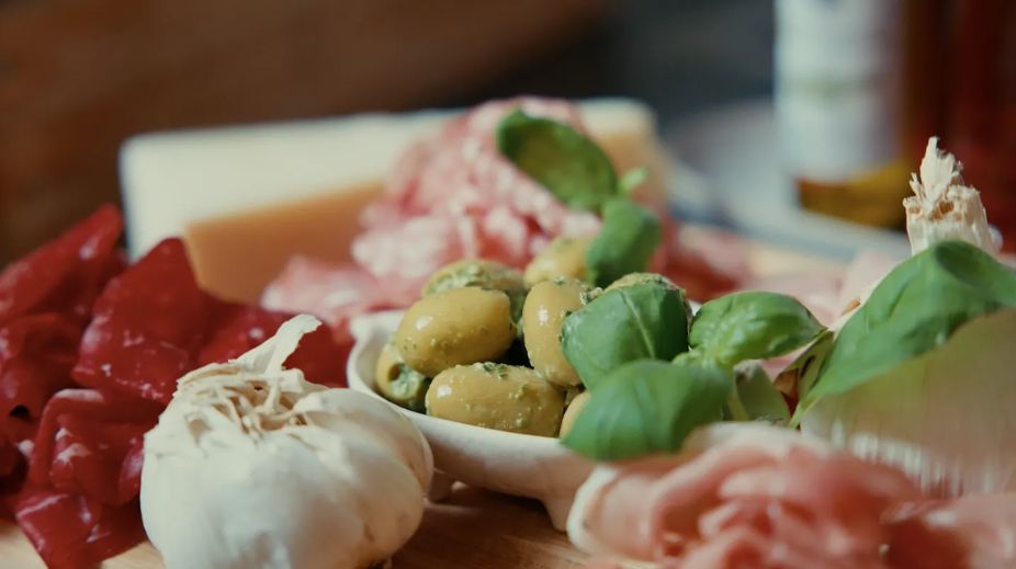 Italiaanse antipasti plank met burrata, olijven, parmaham en basilicum